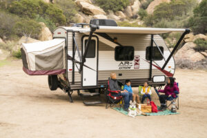 small travel trailer with awning out and campsite
